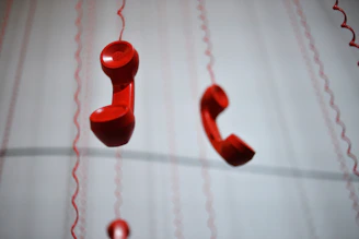 Red phone handsets hang from above