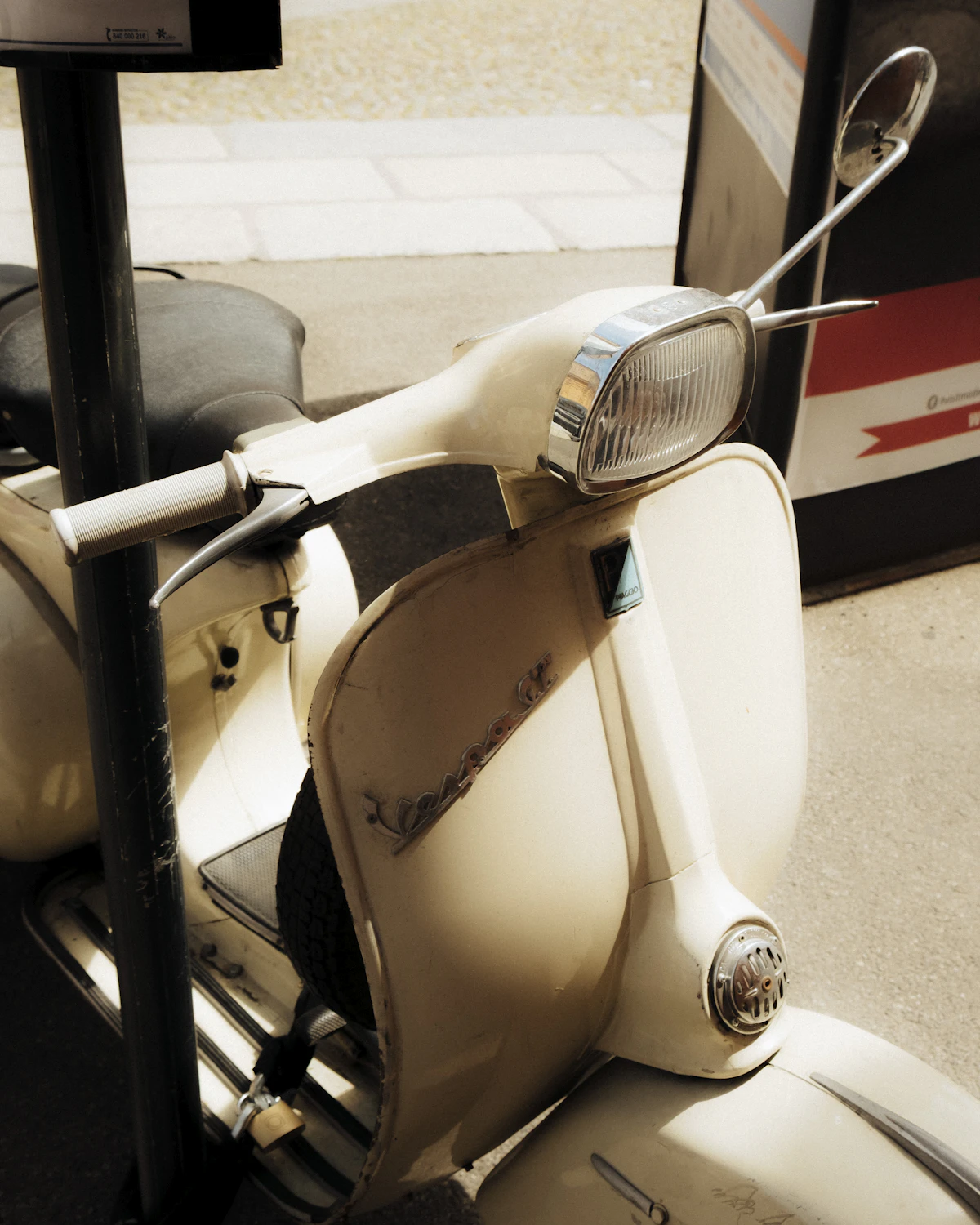 Classic cream-colored Vespa scooter parked in the street