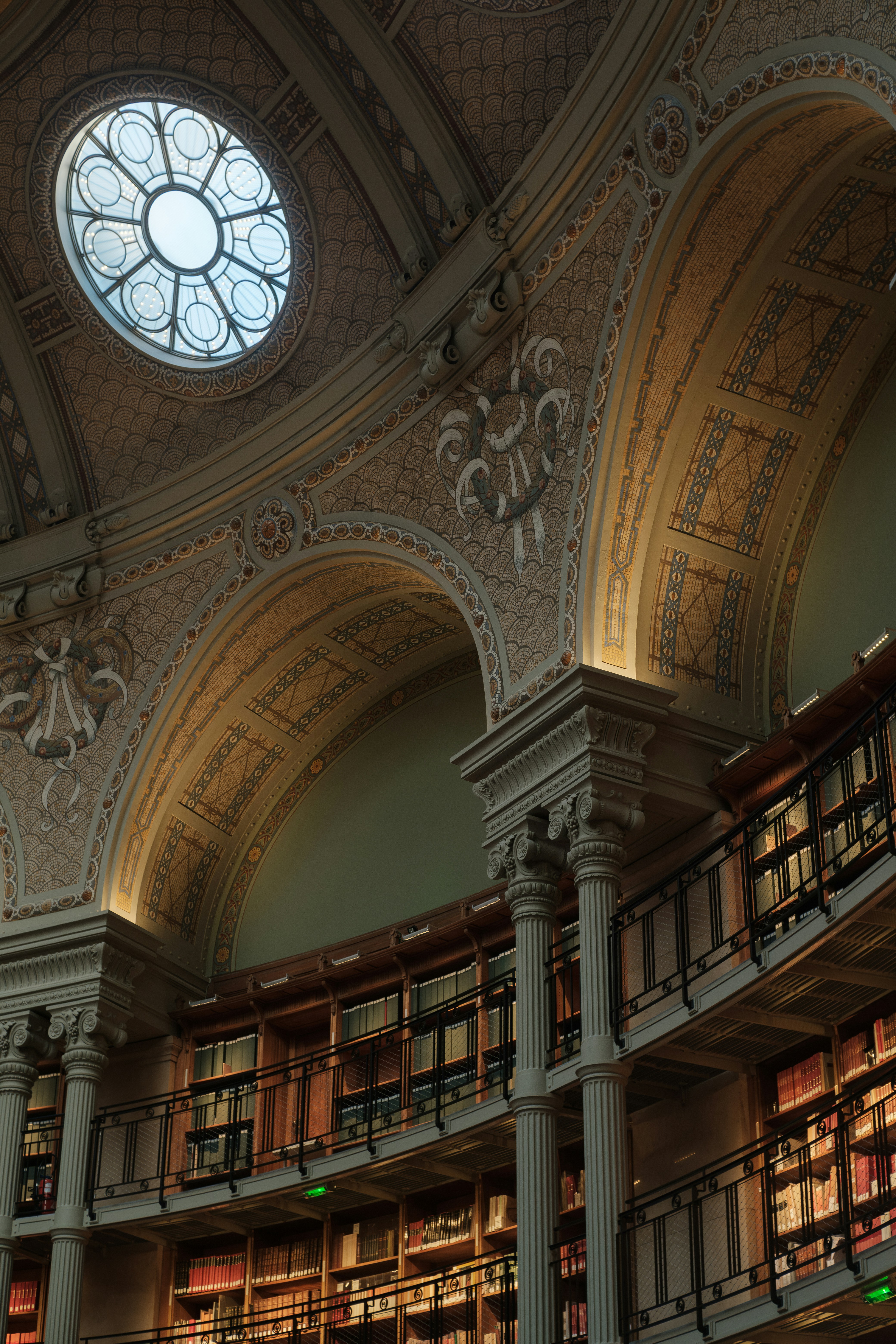An ornate library's ceiling and bookshelves are featured.