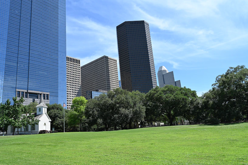 Green park with city skyline in the background.