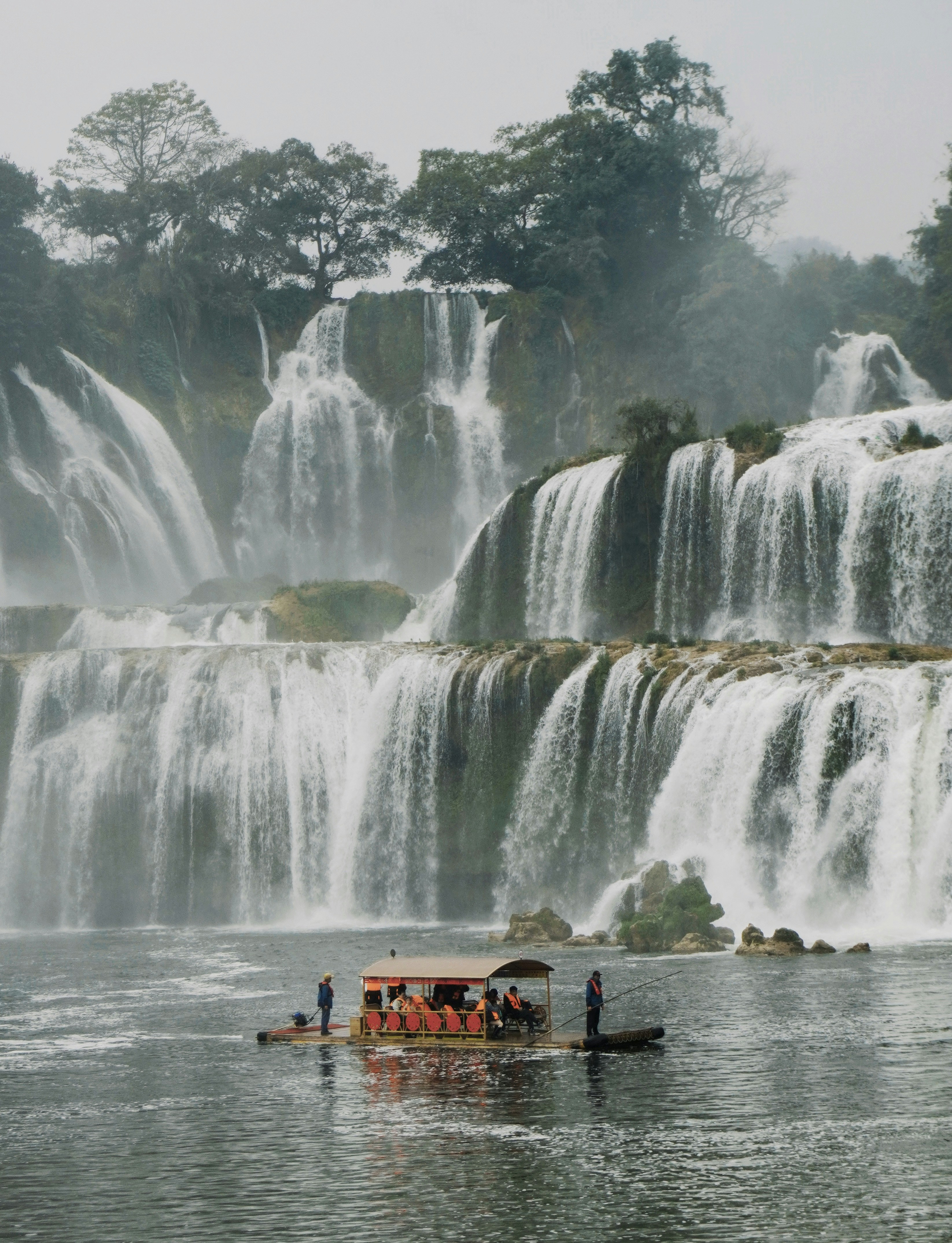 Tourists ride a boat below a majestic waterfall. photo – Free Travel ...