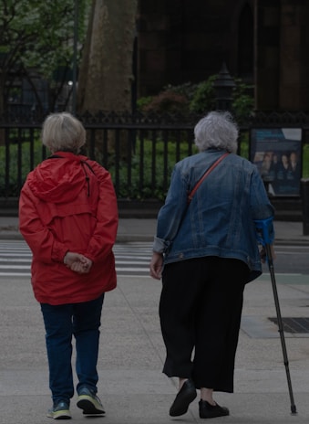 Two elderly women stroll down the street.