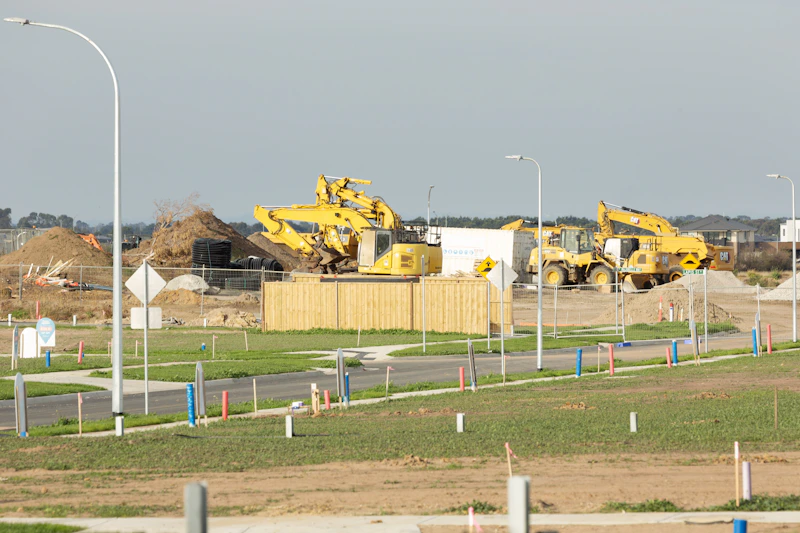 Excavators clearing and grading a raw residential development site