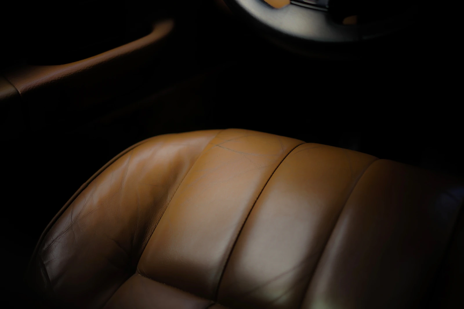 Close view of a premium brown leather vehicle seat showing material texture and interior comfort