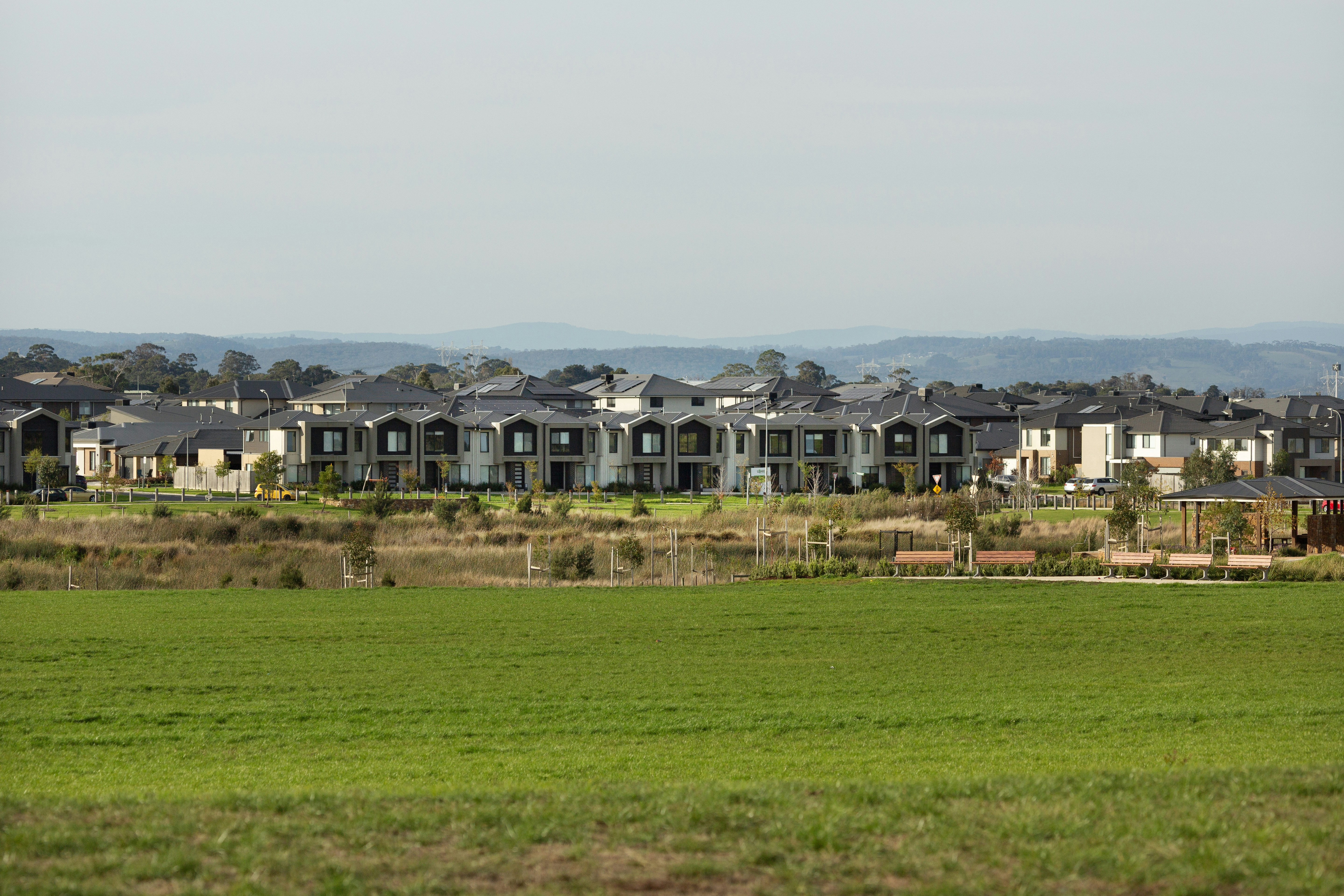 Large buildings sit atop a grassy field.