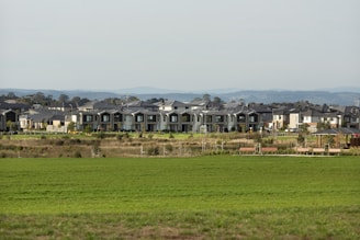 Large buildings sit atop a grassy field.