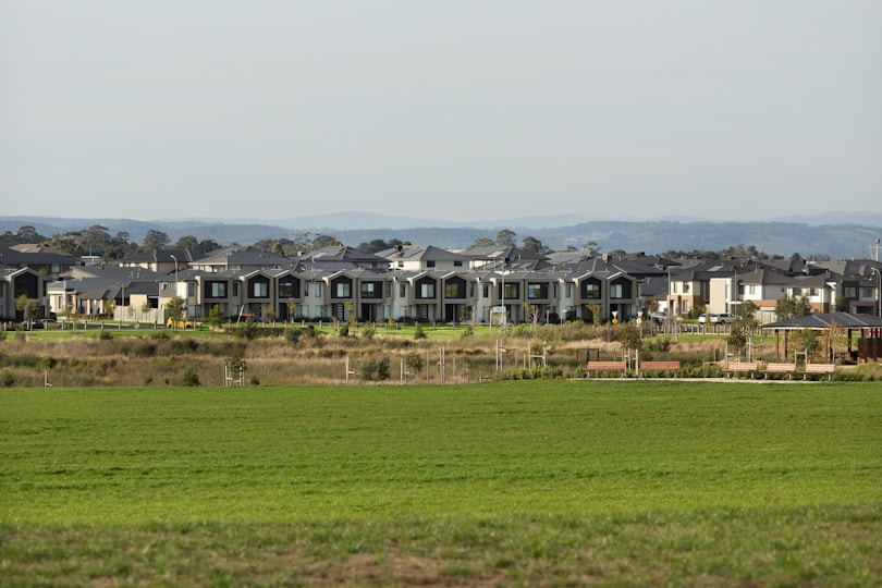 Large buildings sit atop a grassy field.