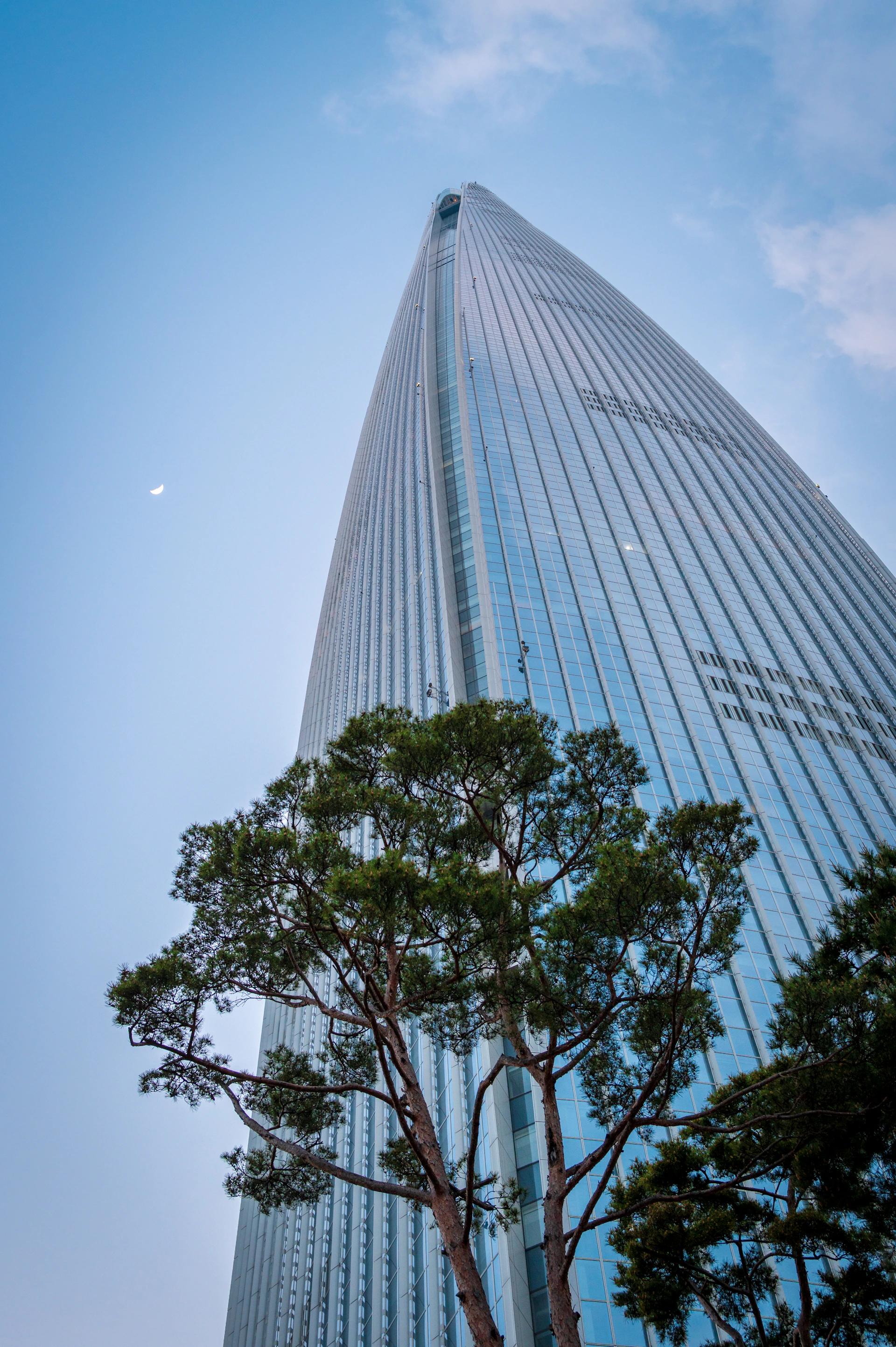 Tall skyscraper reaches toward a clear blue sky.
