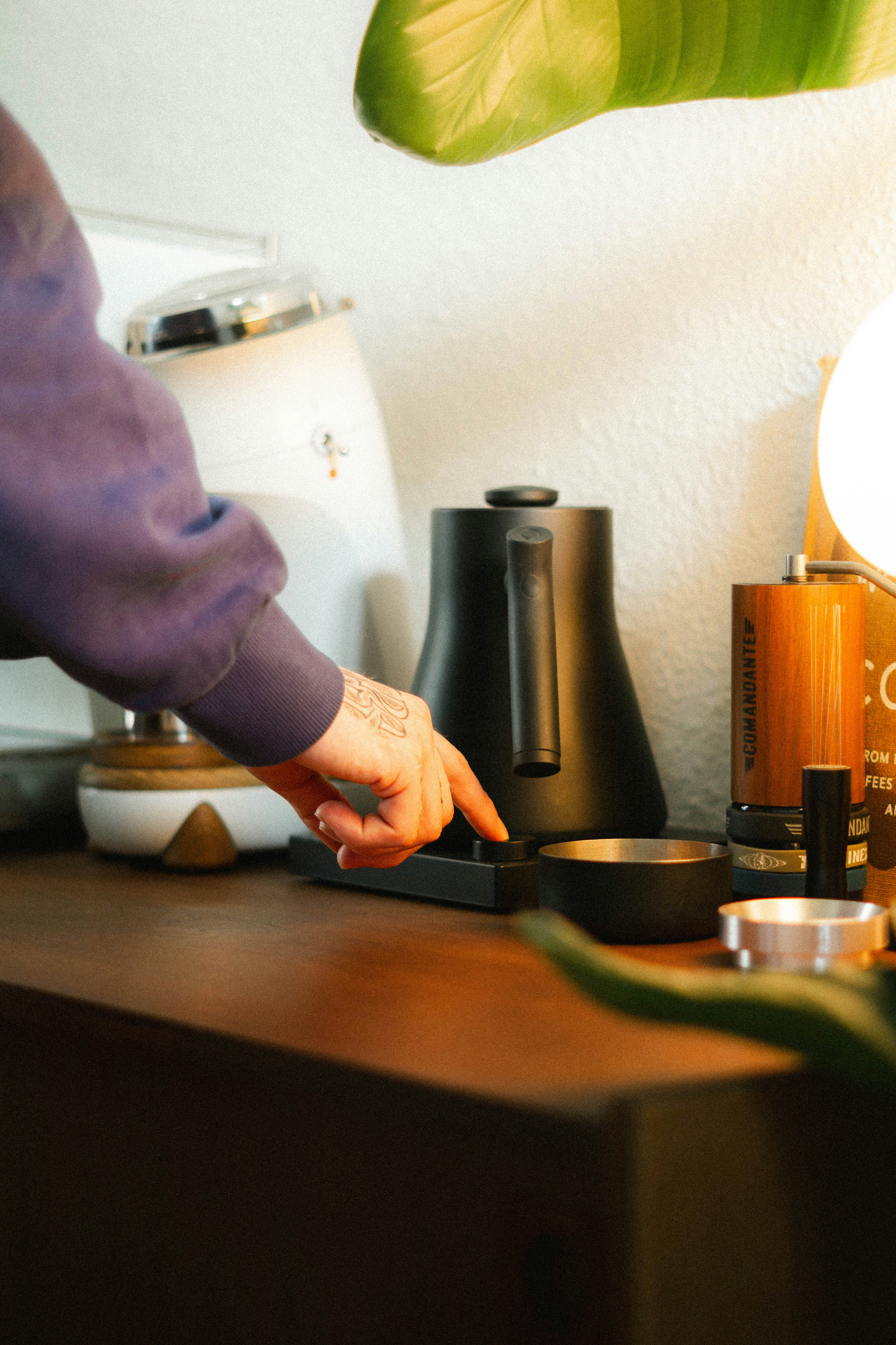 Person uses a coffee kettle on a kitchen counter.