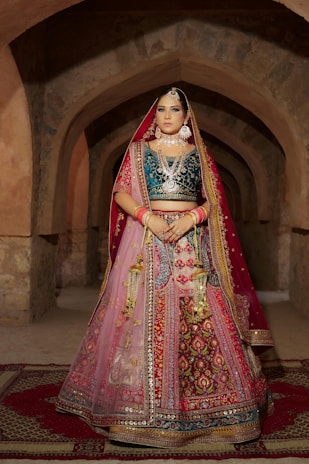 An elegantly dressed woman poses in a doorway.