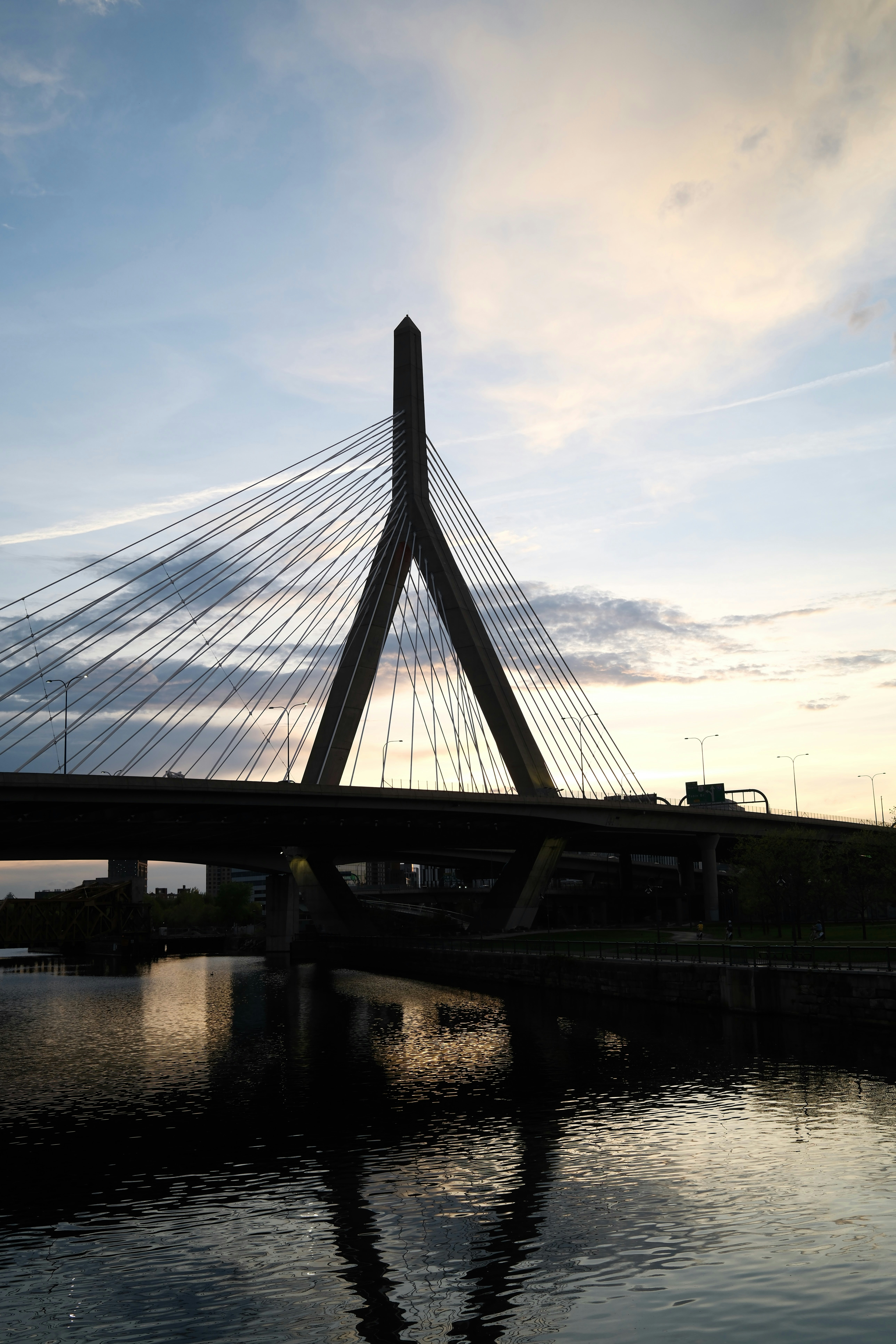 El puente atirantado se refleja en aguas tranquilas al atardecer.