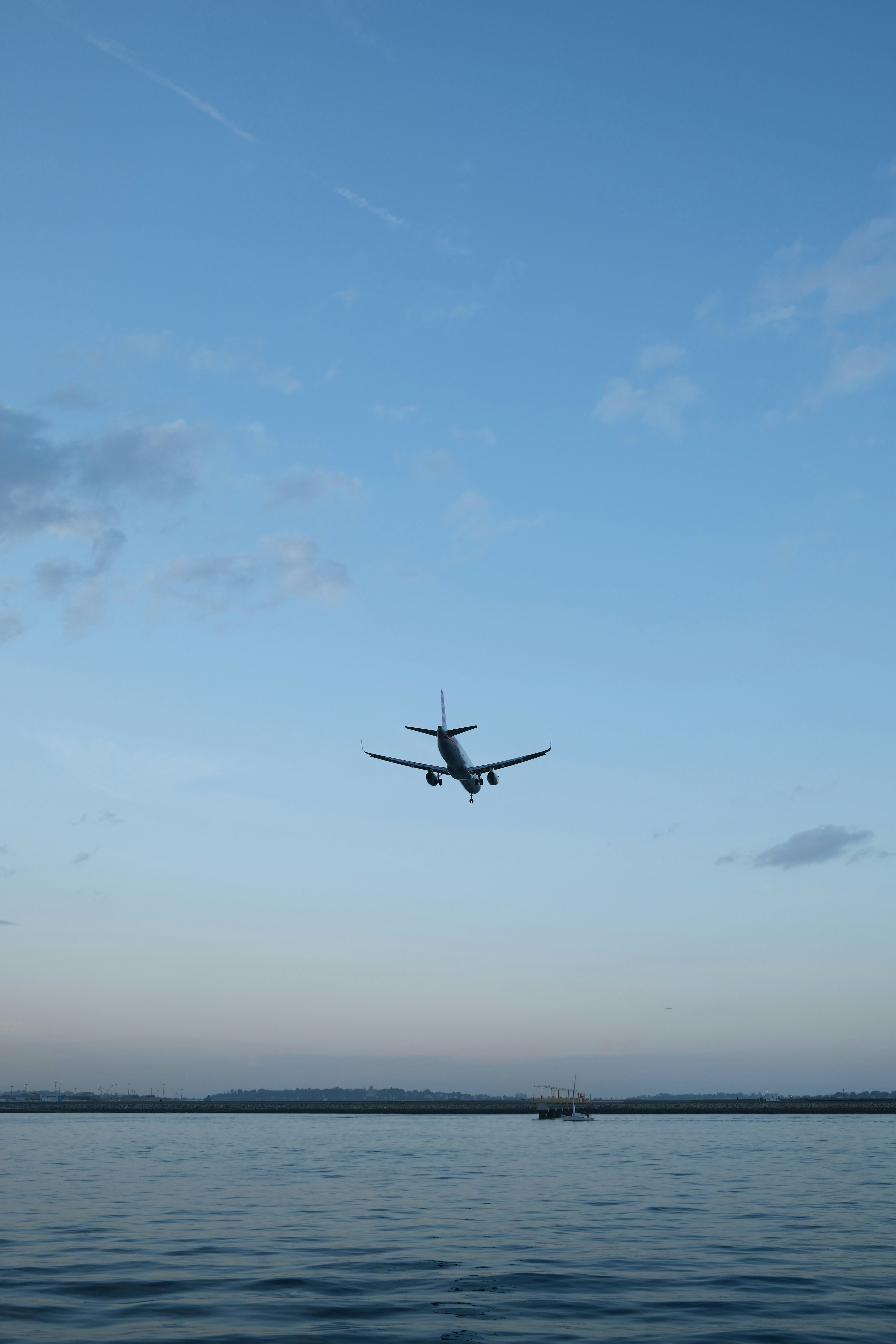 An airplane flies low over the water.