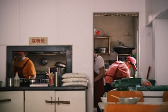 Chefs prepare food in a busy restaurant kitchen.