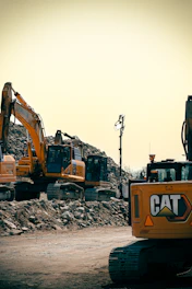 Yellow construction equipment and rubble are visible.