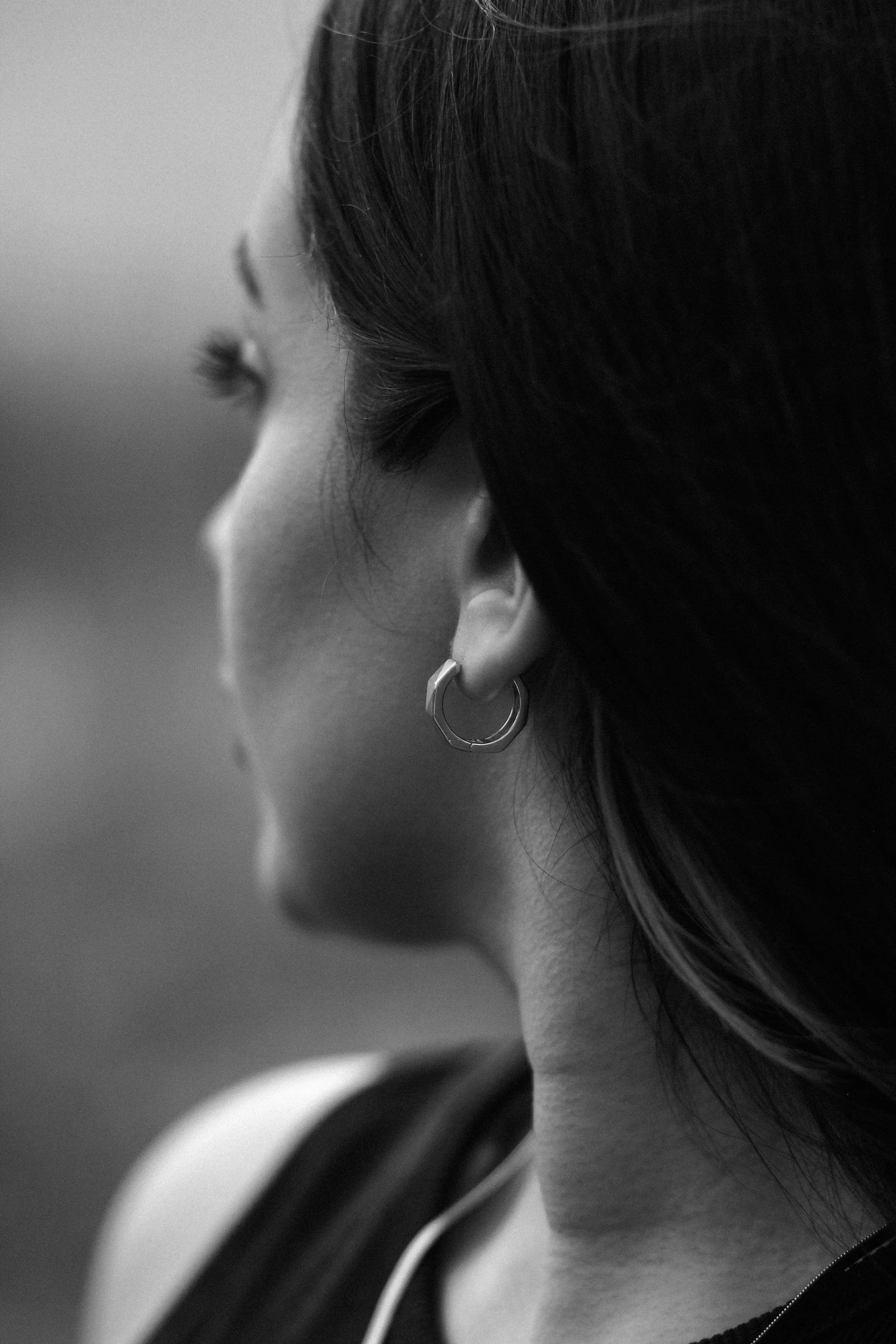 A woman gazes off into the distance in a quiet, contemplative pose.