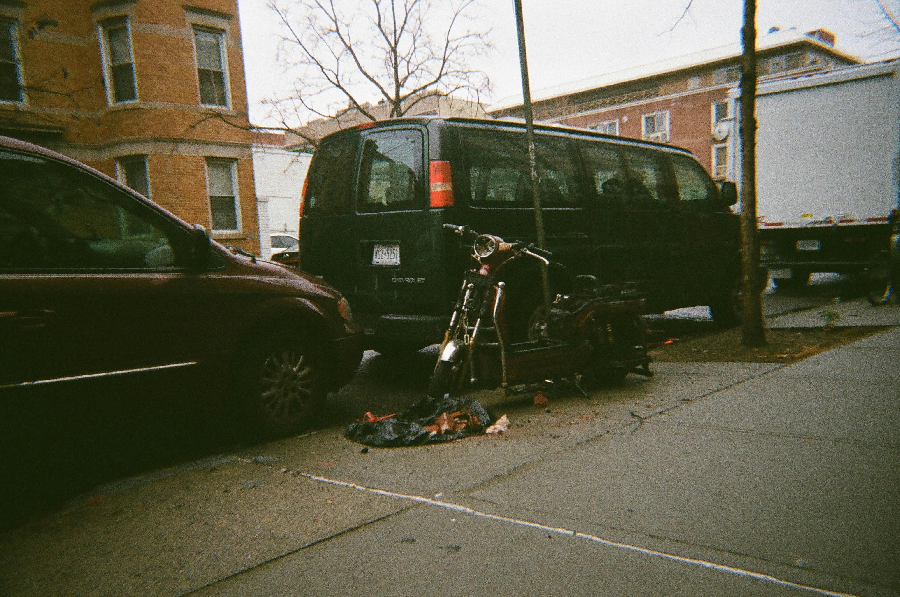 Broken black motorcycle in Astoria, Queens, New York City on film