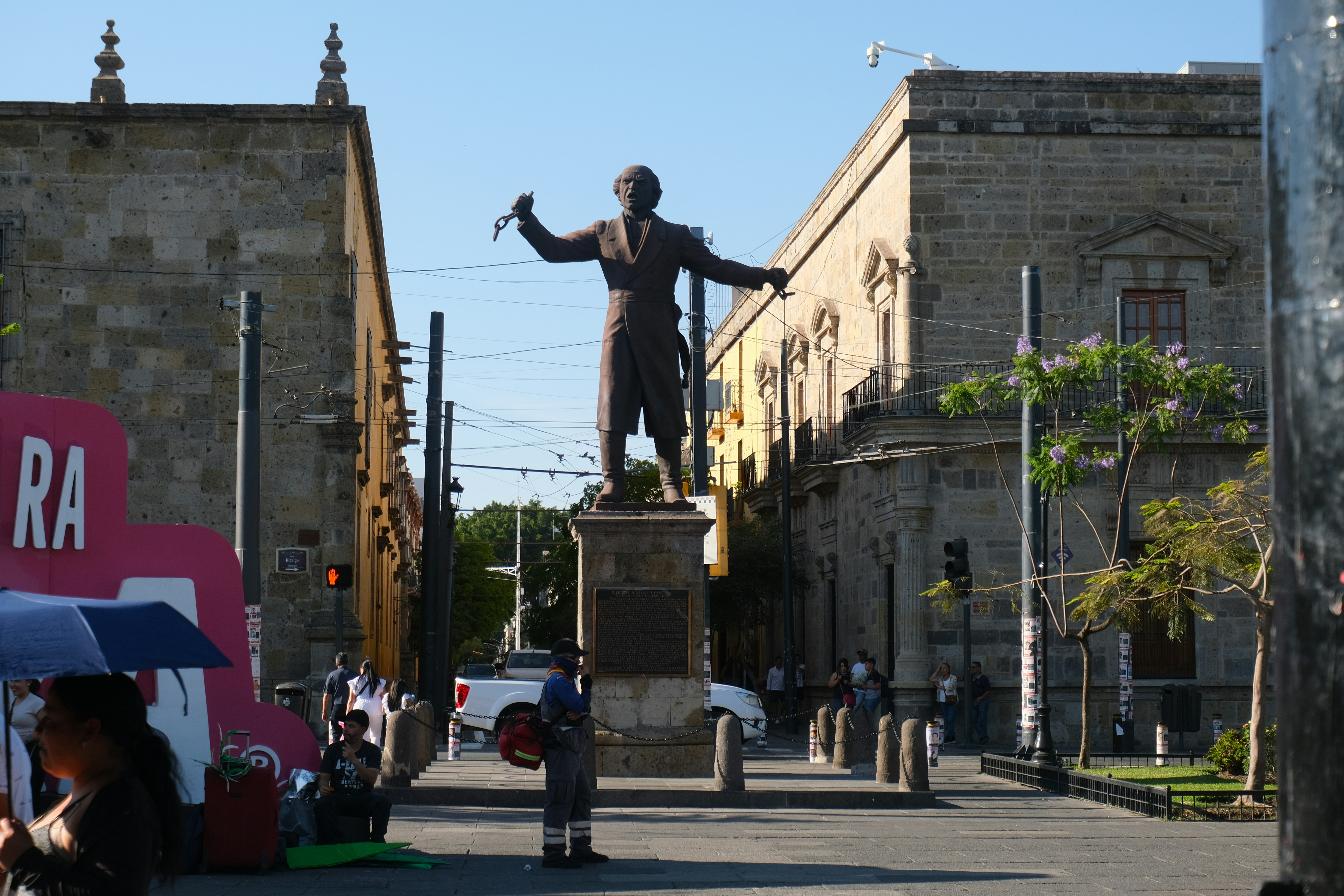Statue of a man stands in a city street.
