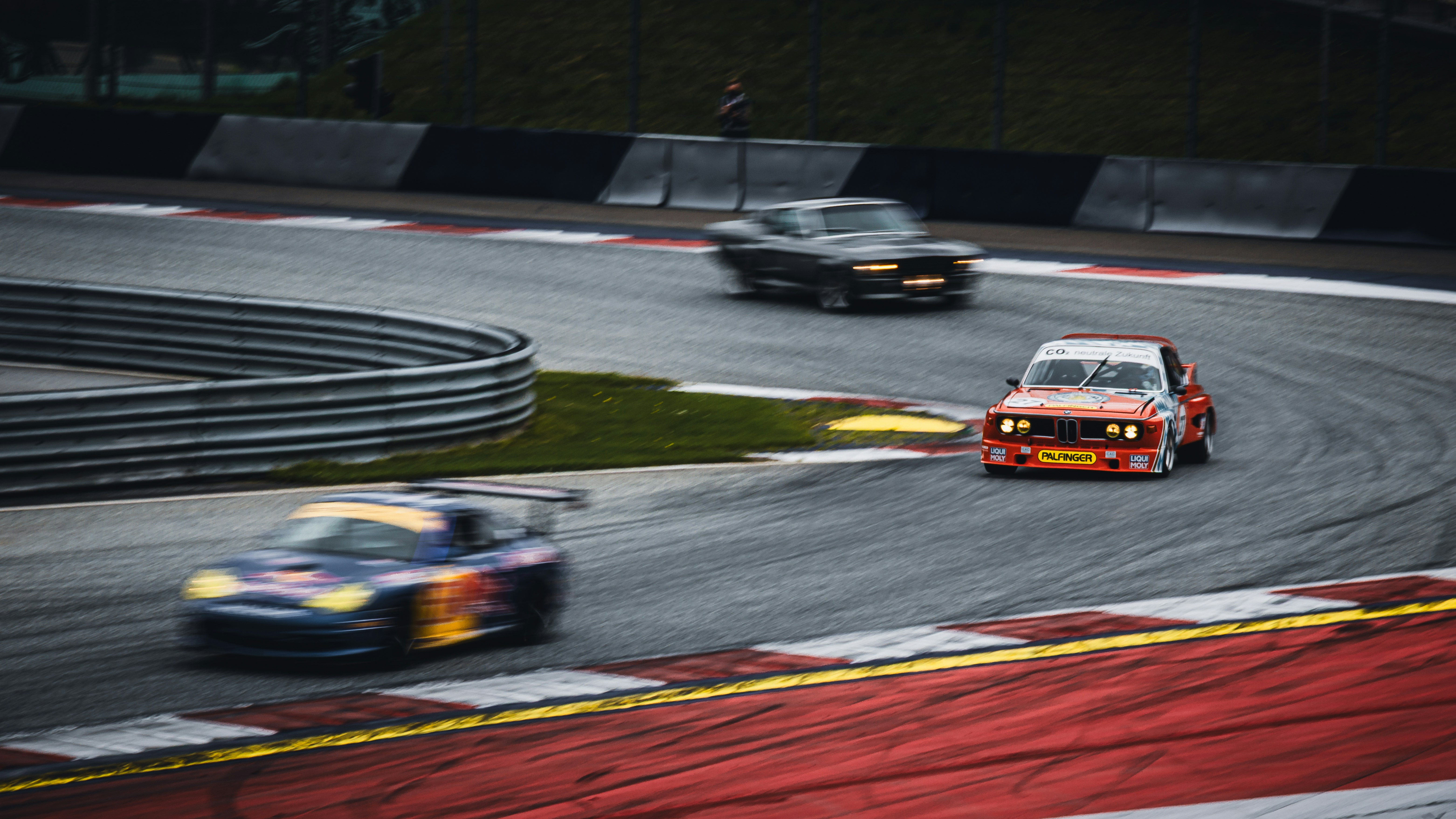 Race cars speeding around a sharp racetrack curve.