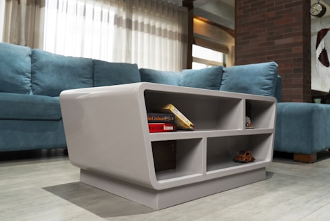 A modern coffee table with books and shelves.