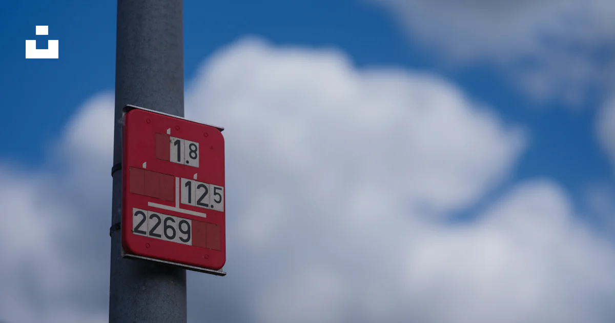 Red Polysmic Sign A red sign is mounted on a pole. photo – Free Blue Image on Unsplash