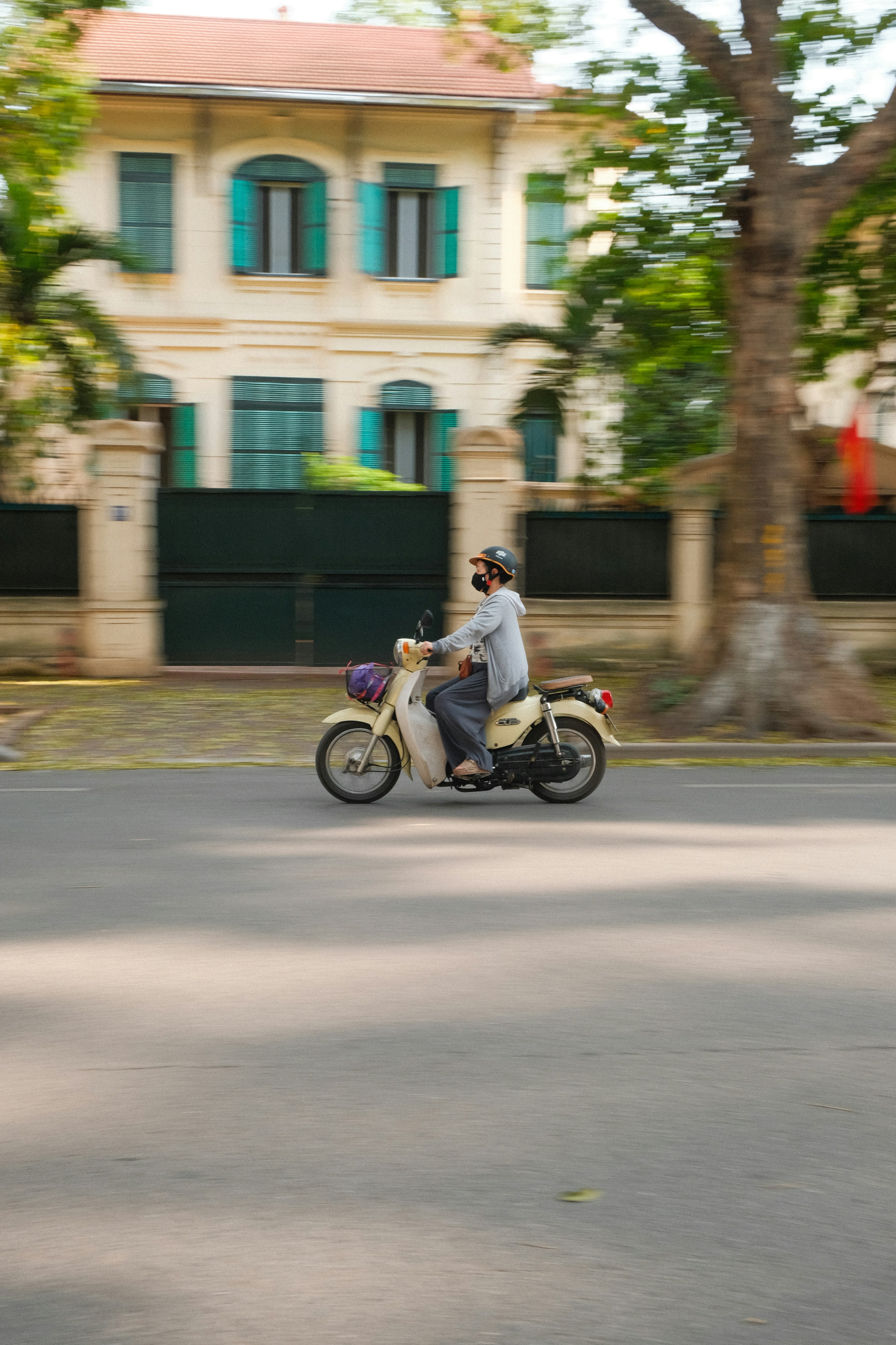 A person rides a motorbike down the street.