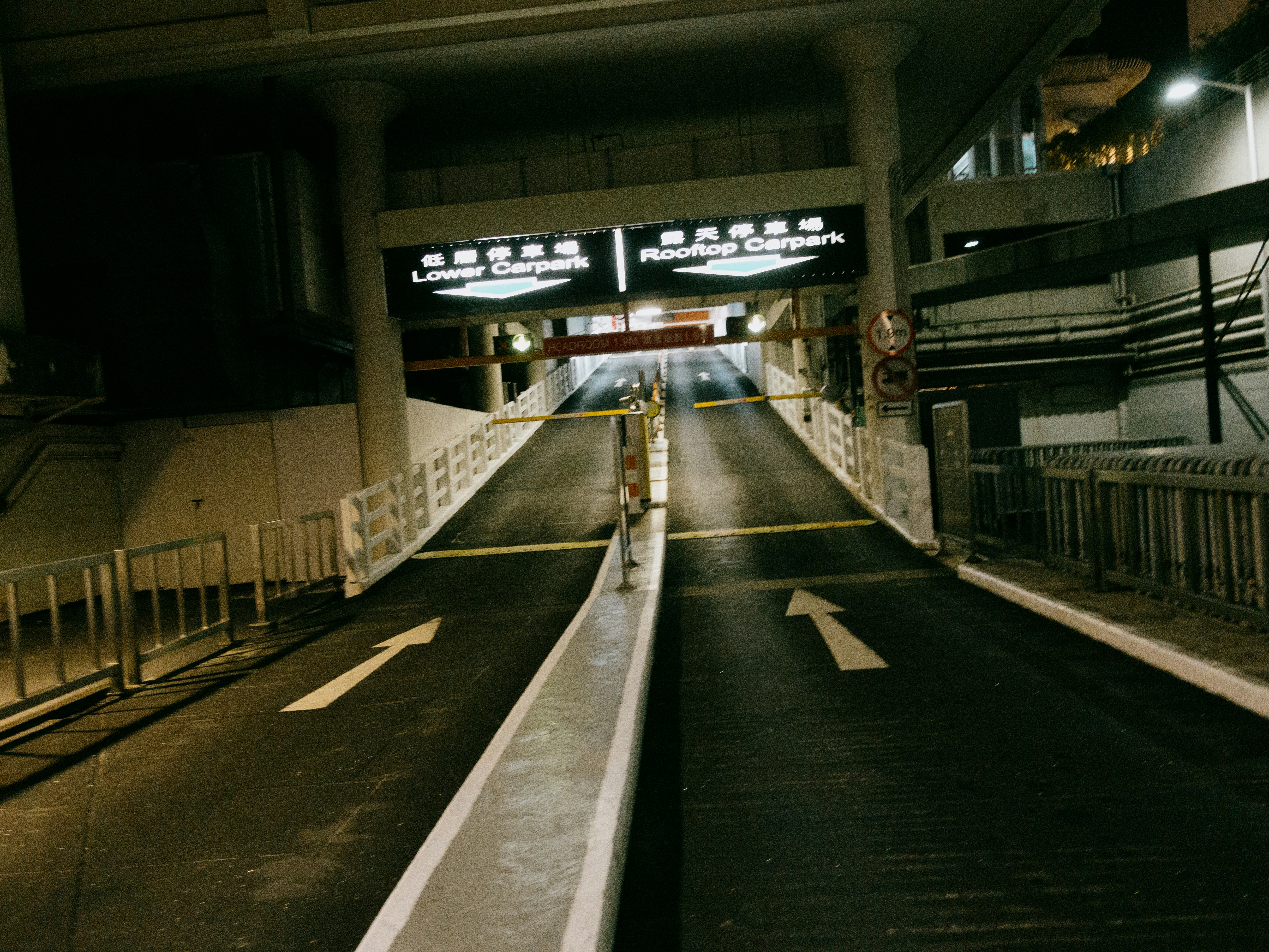 An empty parking garage entrance with directional arrows.