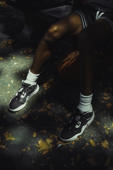 Basketball player rests with ball and sneakers.