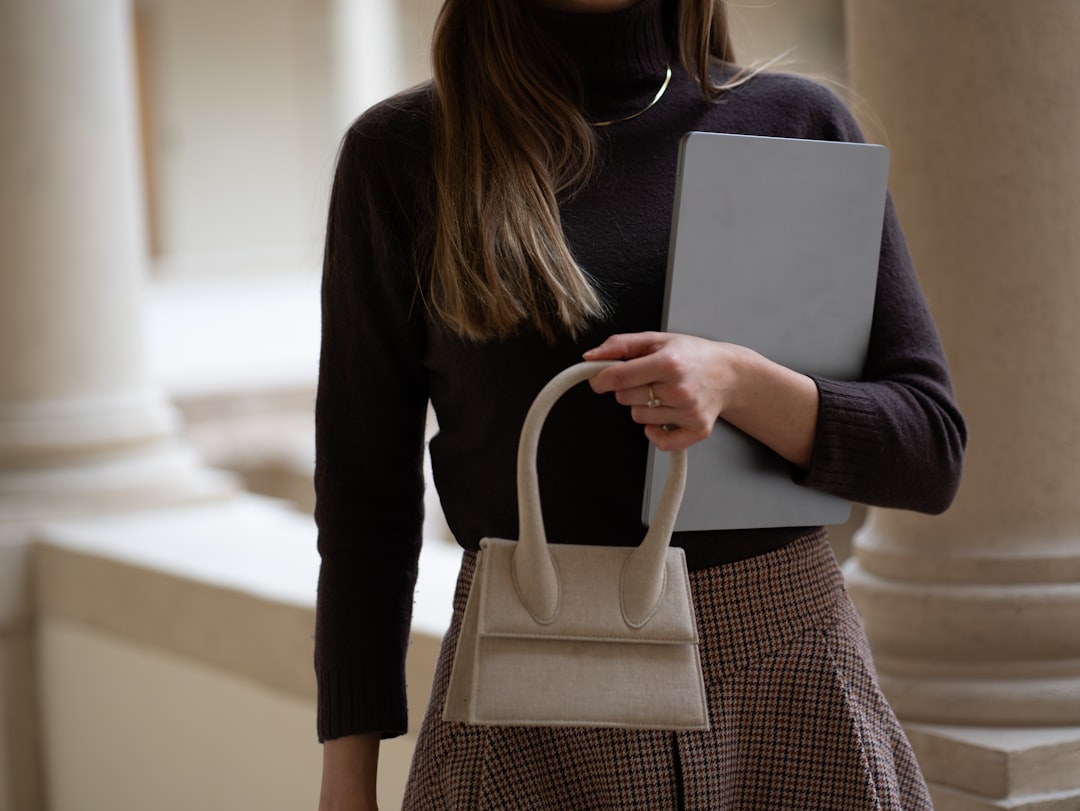 Woman holds a bag and a computer., Chic Business Woman