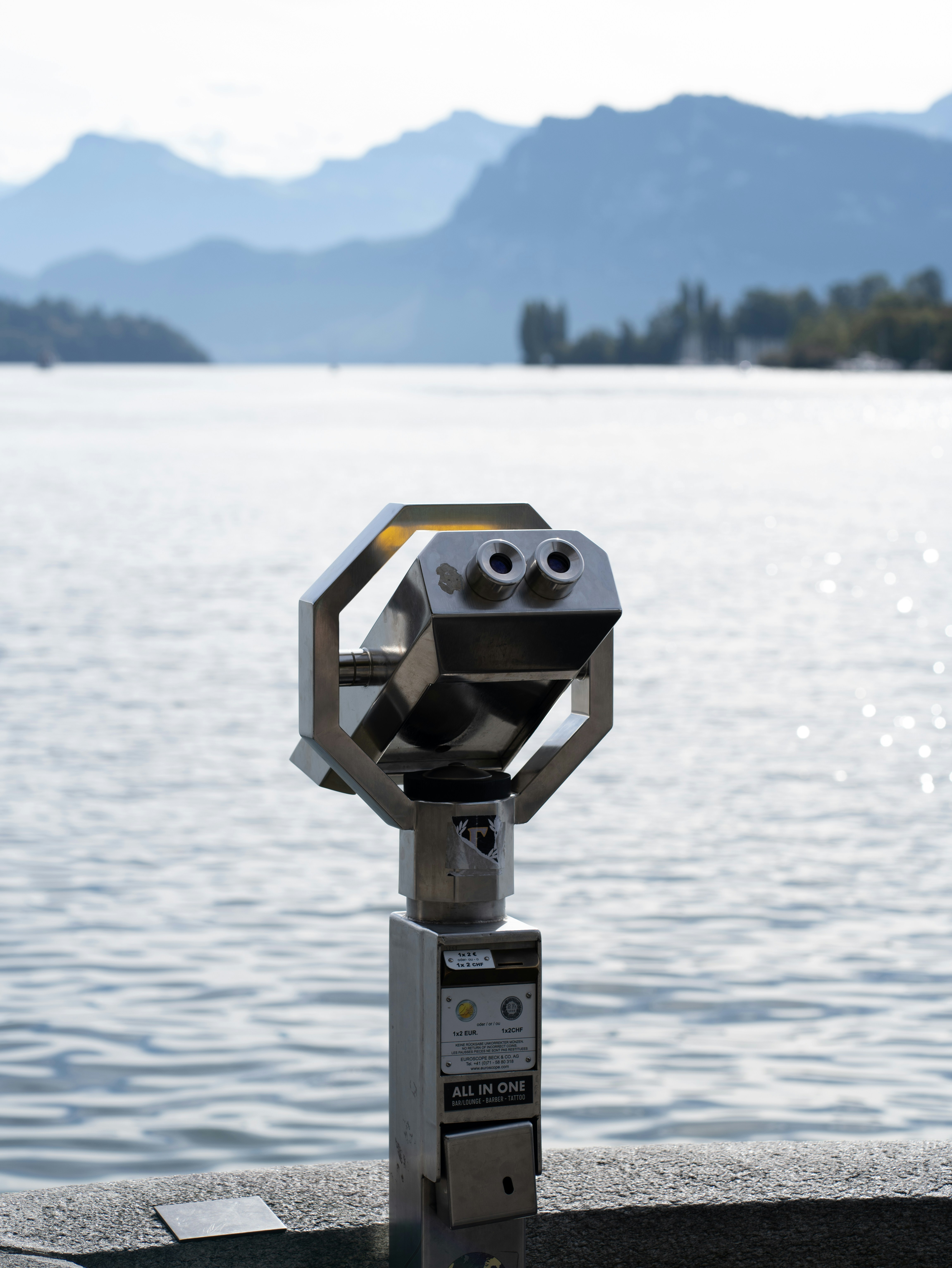Binoculars offer a view of water and mountains.