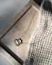 A necklace rests on a textured surface.
