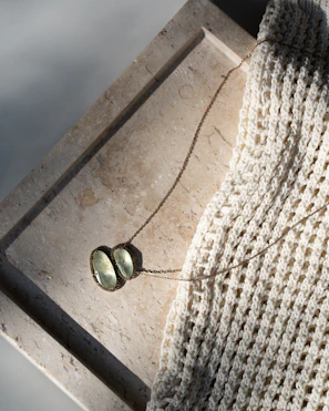 A necklace rests on a textured surface.