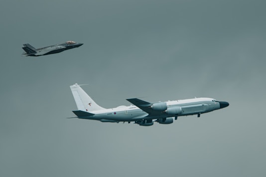 Military aircraft flying through a gray sky.