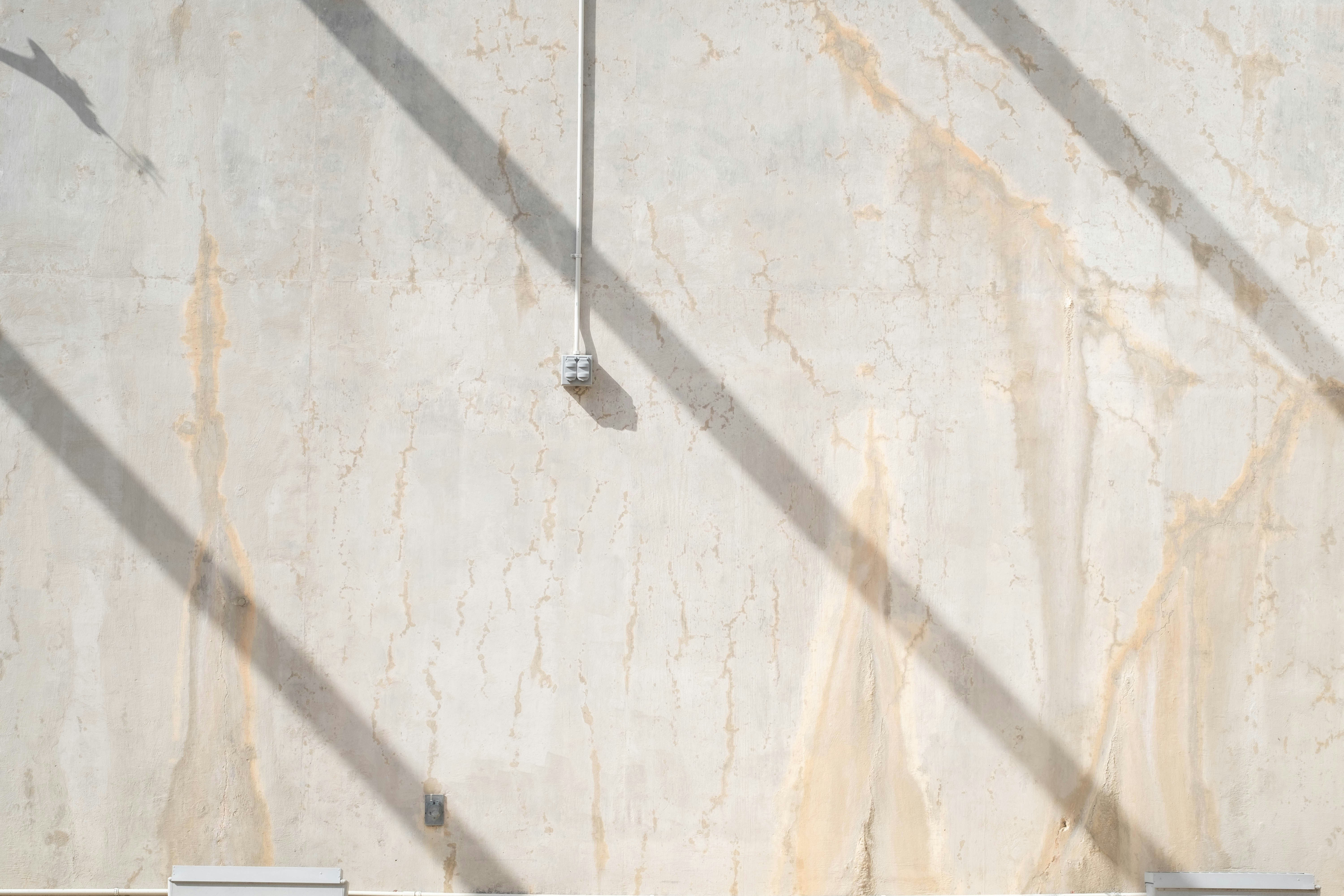 Shadows fall on a textured wall.