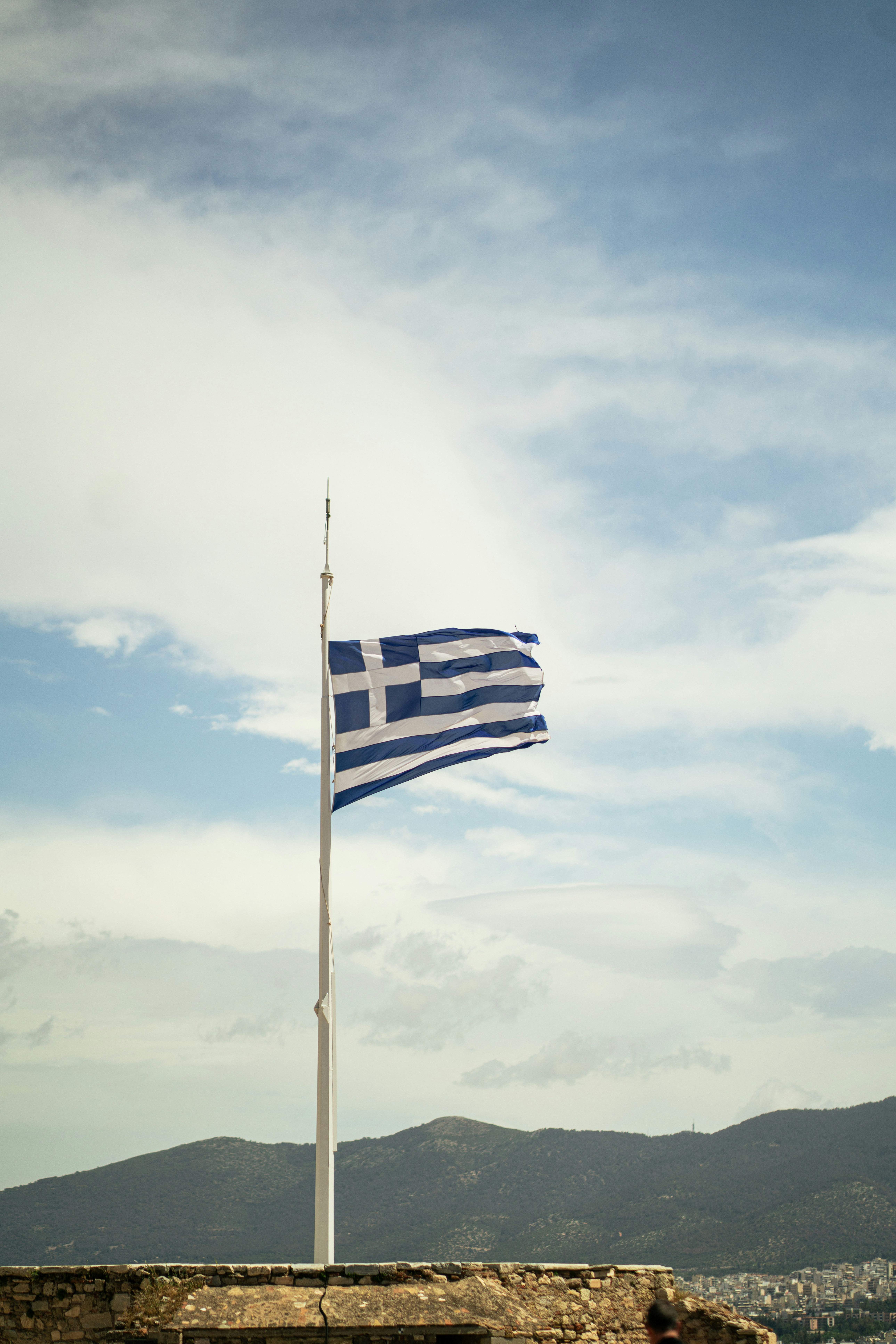 La bandera griega ondea orgullosa contra el cielo.