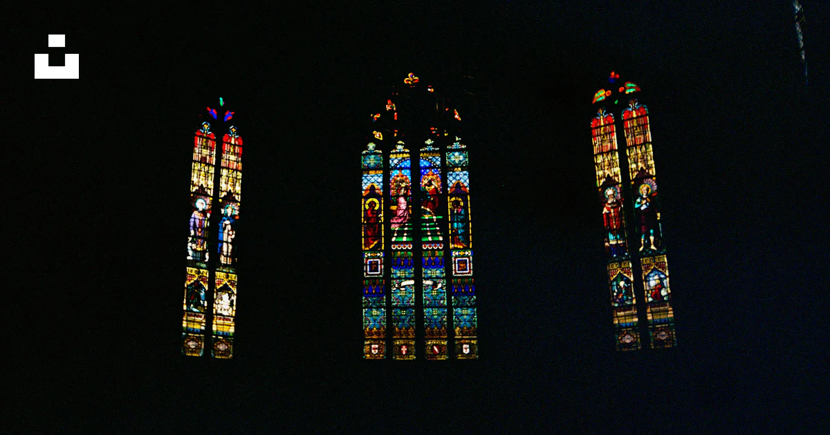 Stained glass windows are illuminated against a dark background. photo ...