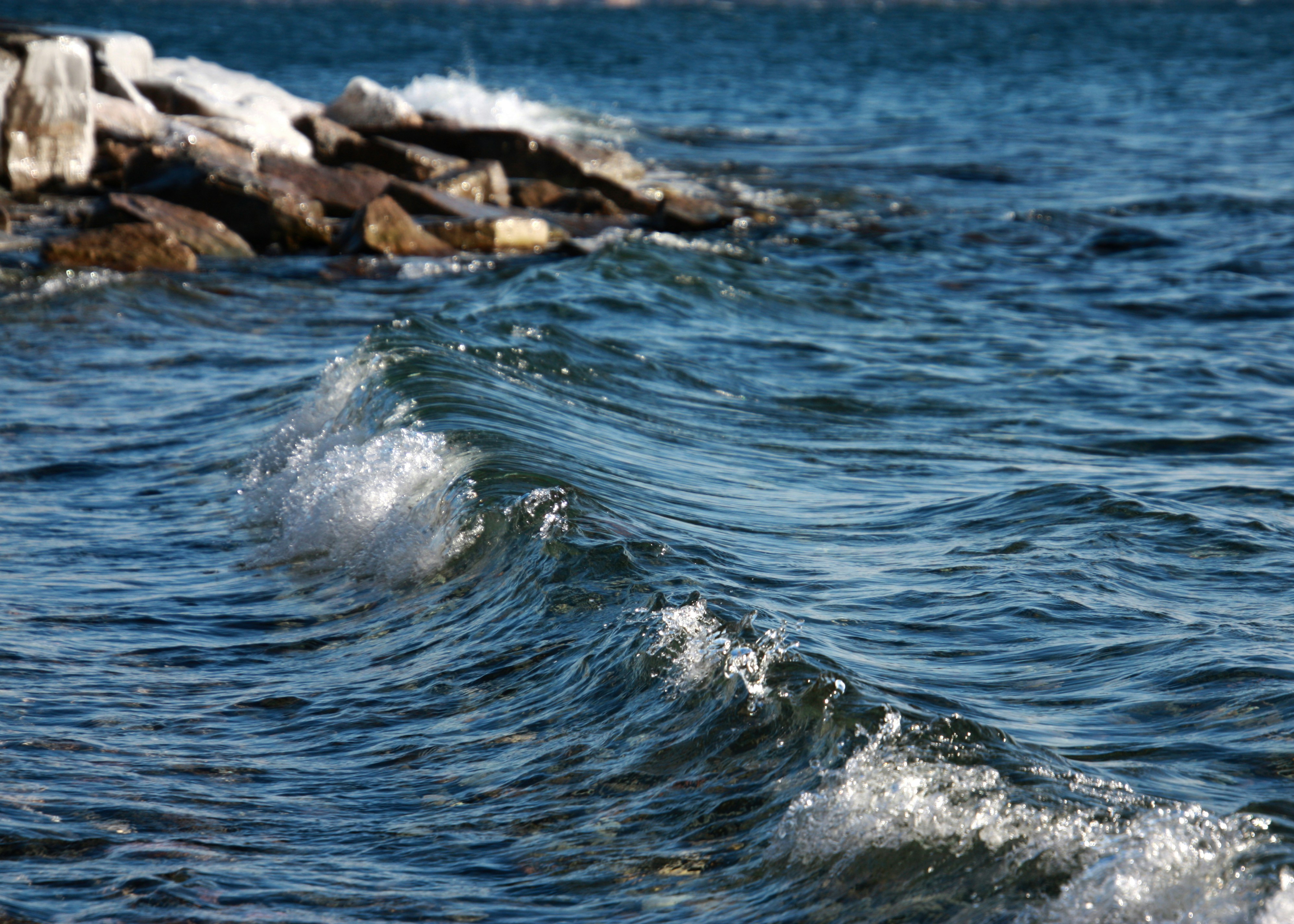 Waves crash towards rocks in the ocean.