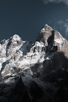 Snow-covered mountains stand tall beneath a dark sky.