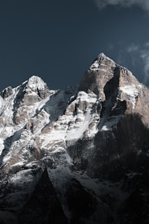 Snow-covered mountains stand tall beneath a dark sky.