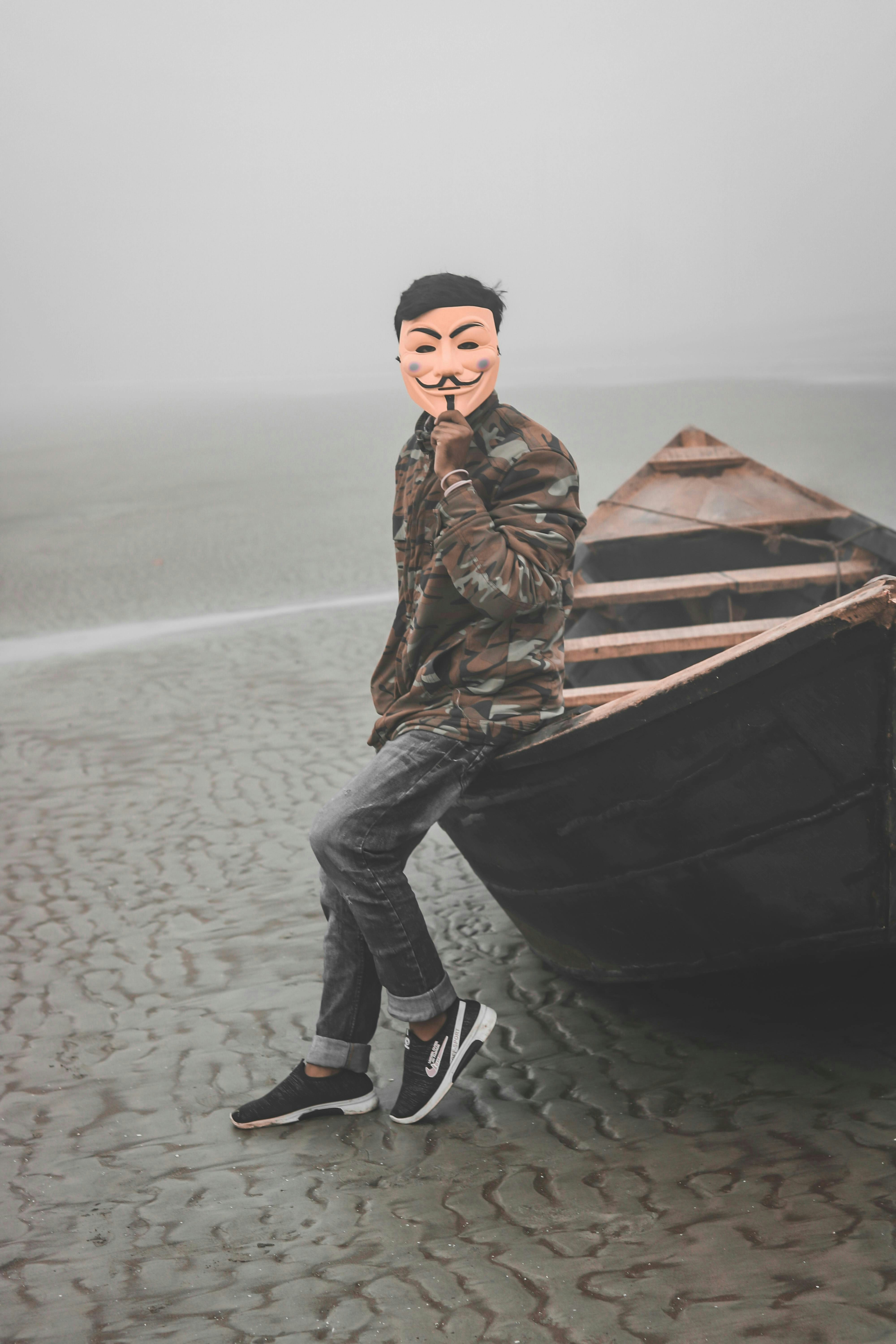 A person wearing a mask near a boat.