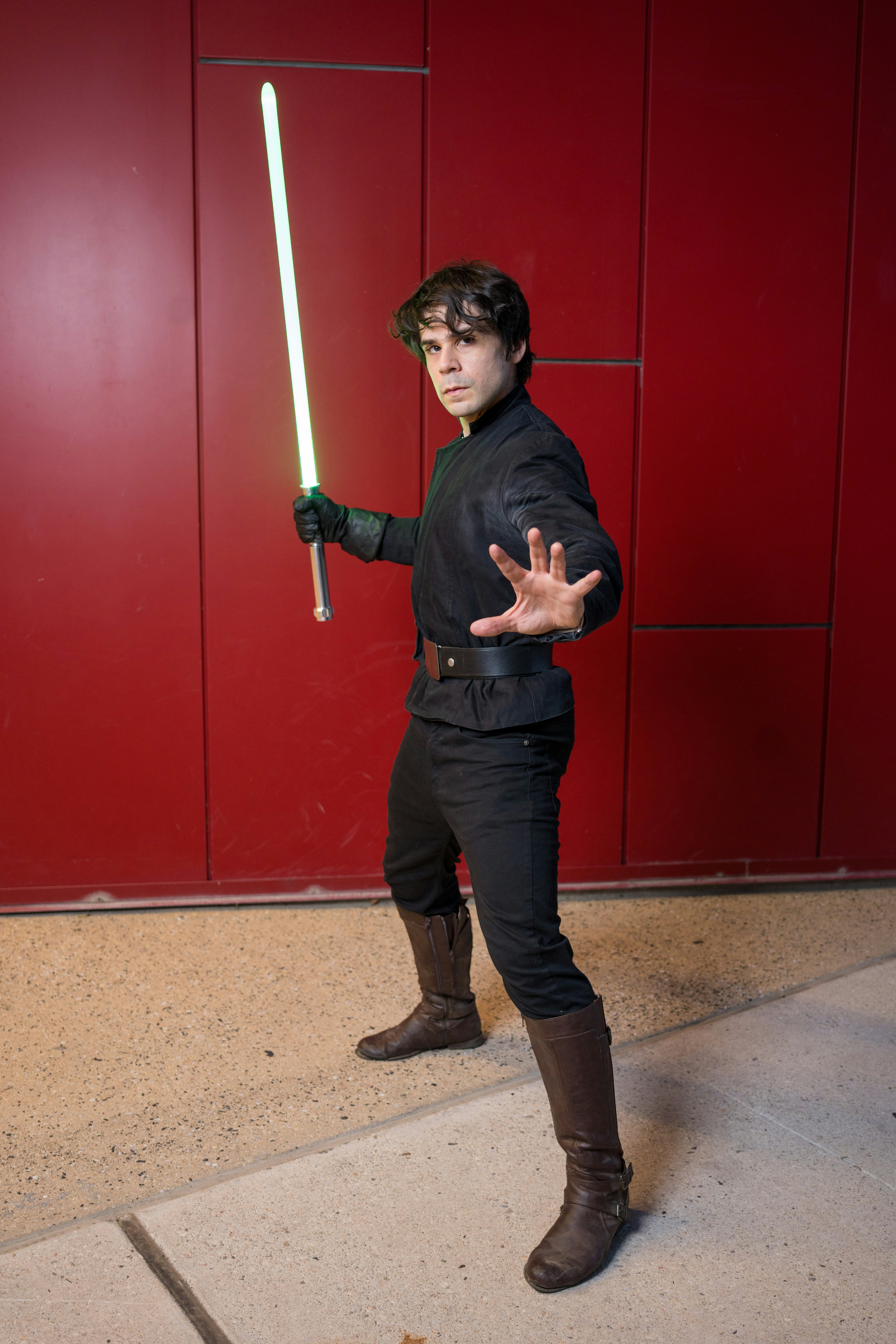 Seseorang cosplay sebagai luke skywalker, dengan lightsaber.