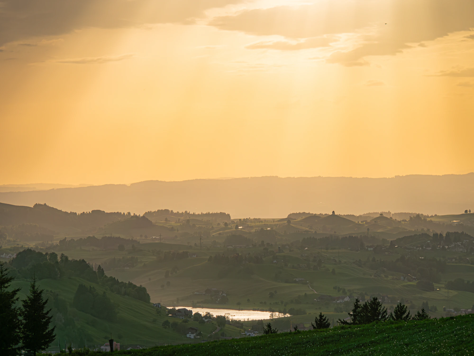 Pôr do sol sobre colinas e lago
