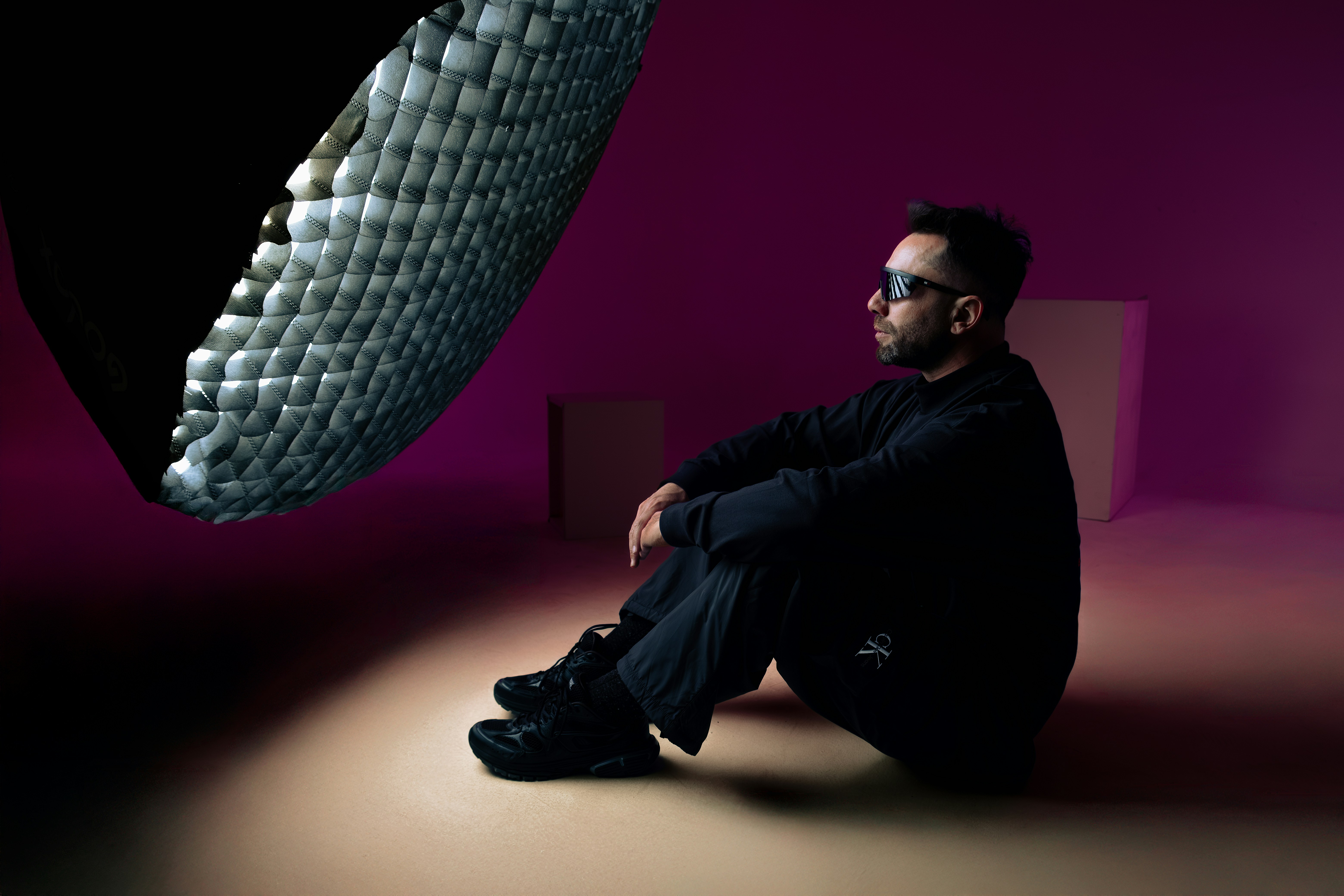A man sits, observing an abstract shape