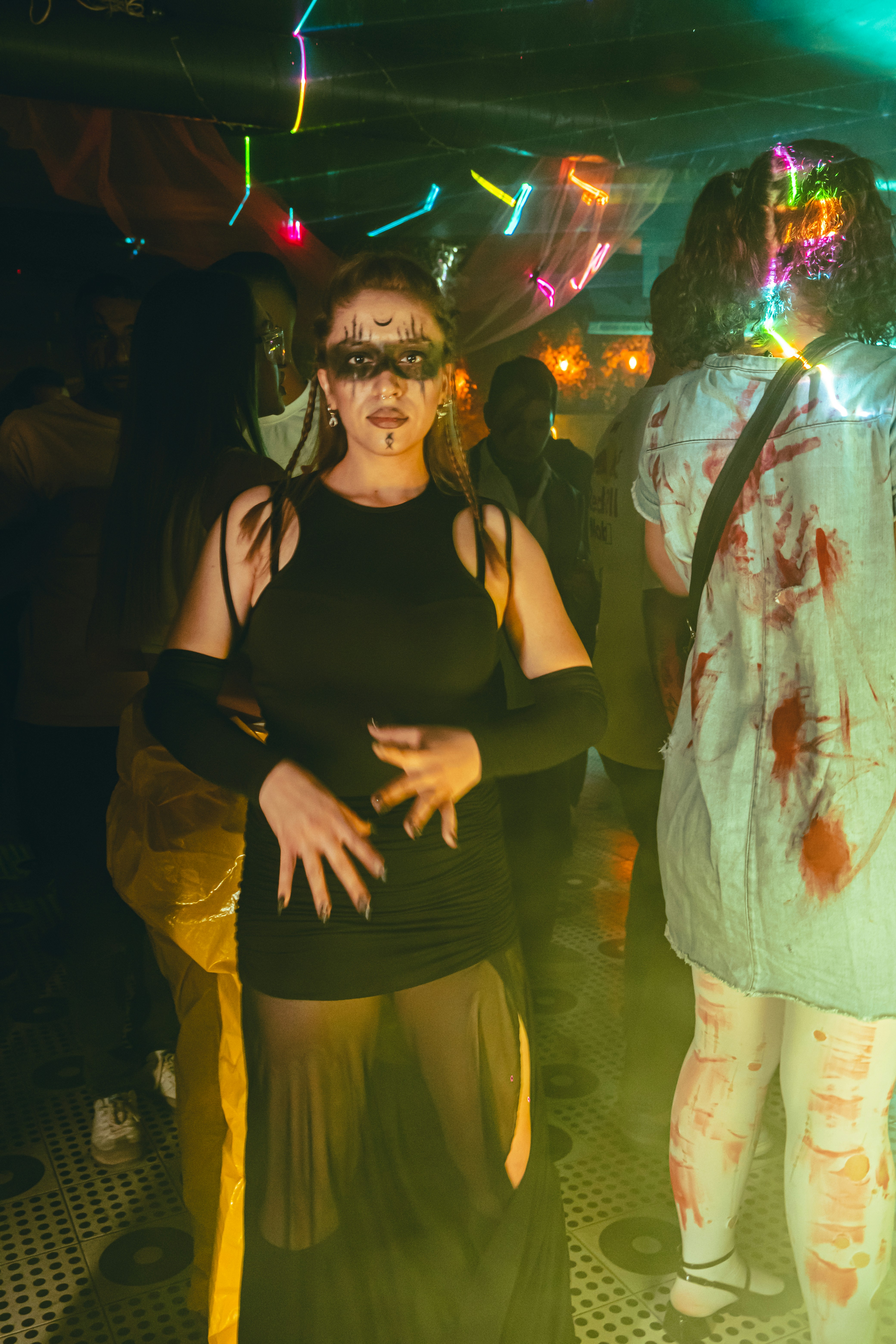 Orang-orang merayakan Halloween dengan kostum di sebuah pesta.