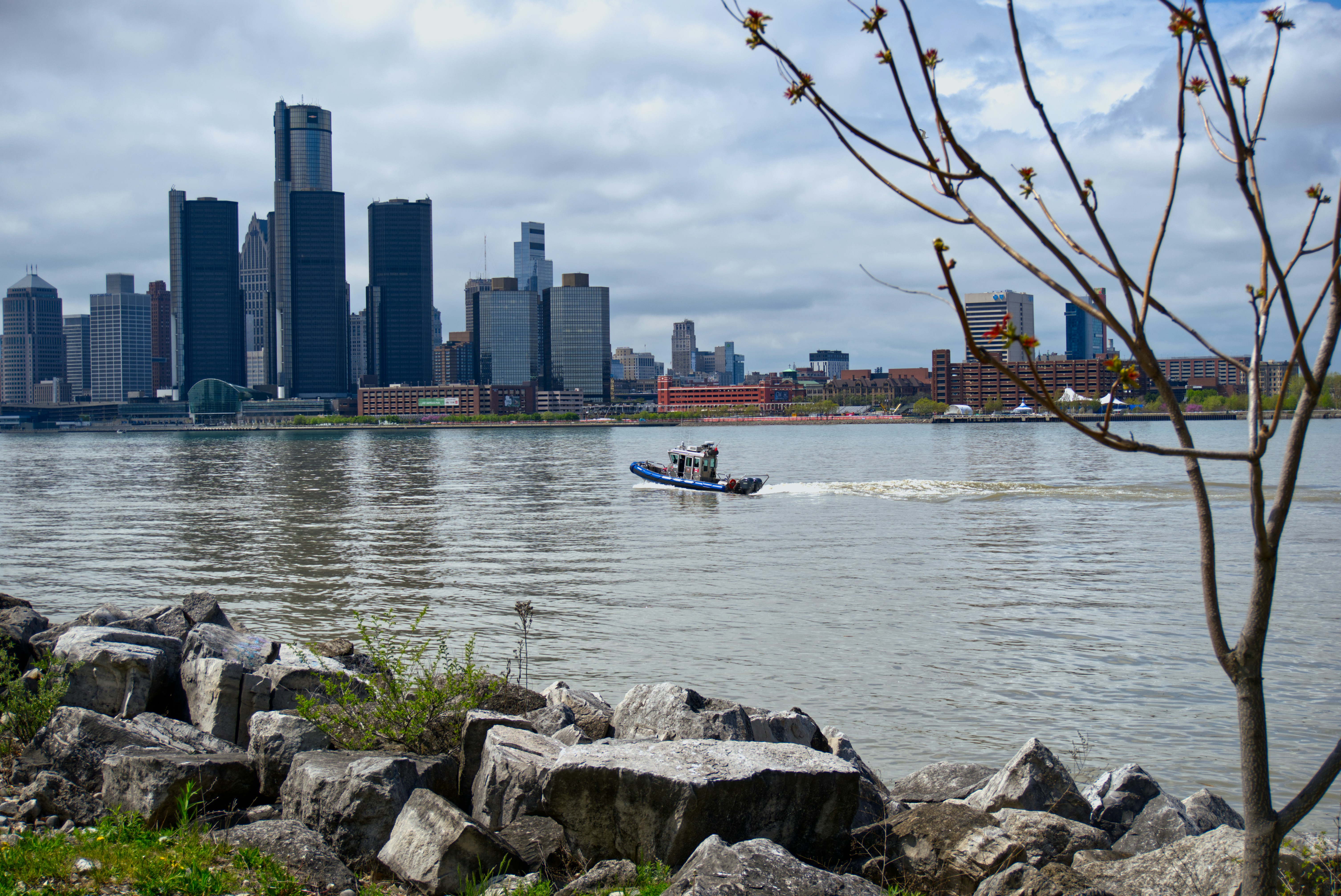 A boat cruises near a city's skyline.