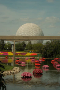 Epcot center's spaceship earth with floating flowers.