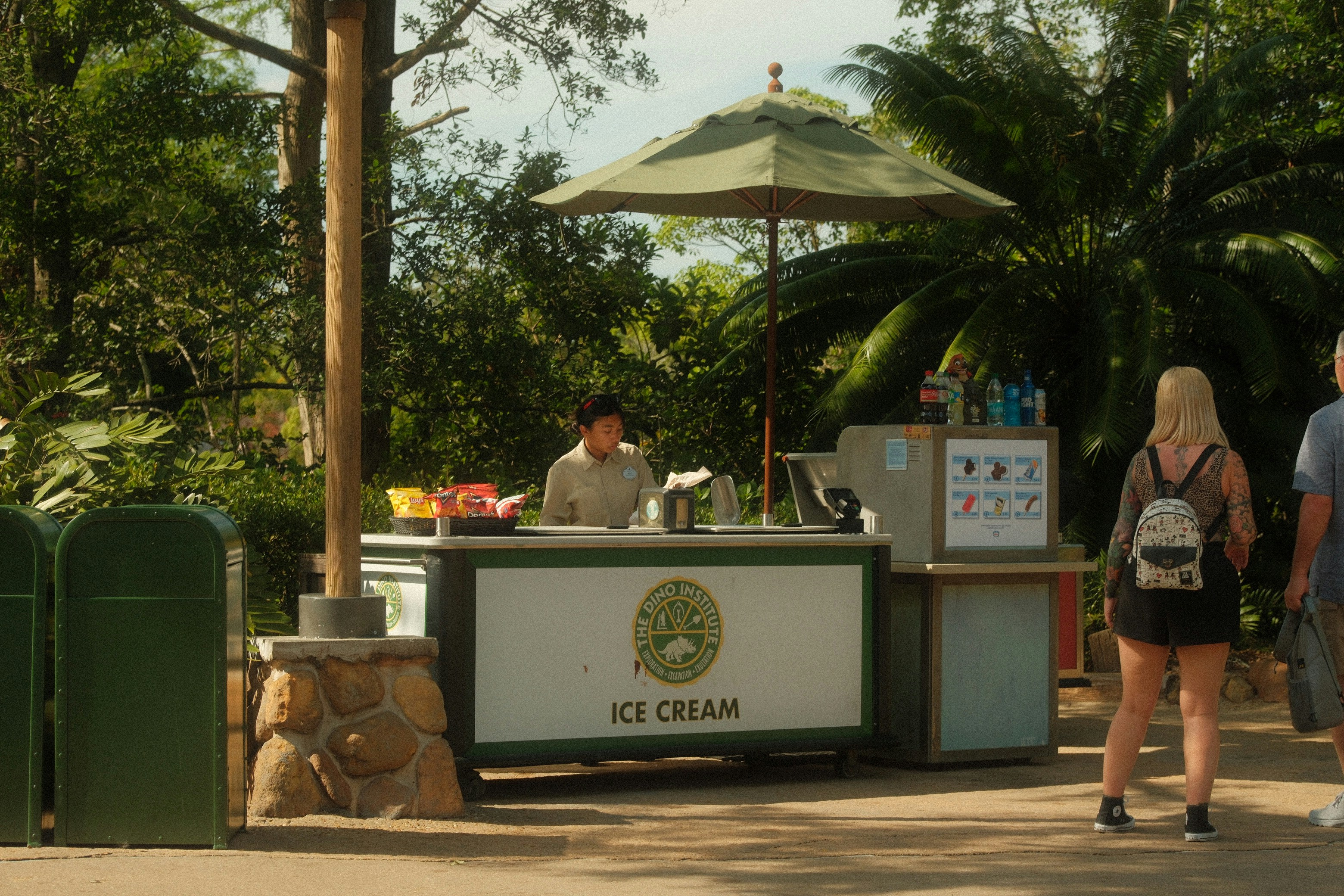 An ice cream stand sells treats in a park.