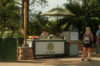 An ice cream stand sells treats in a park.