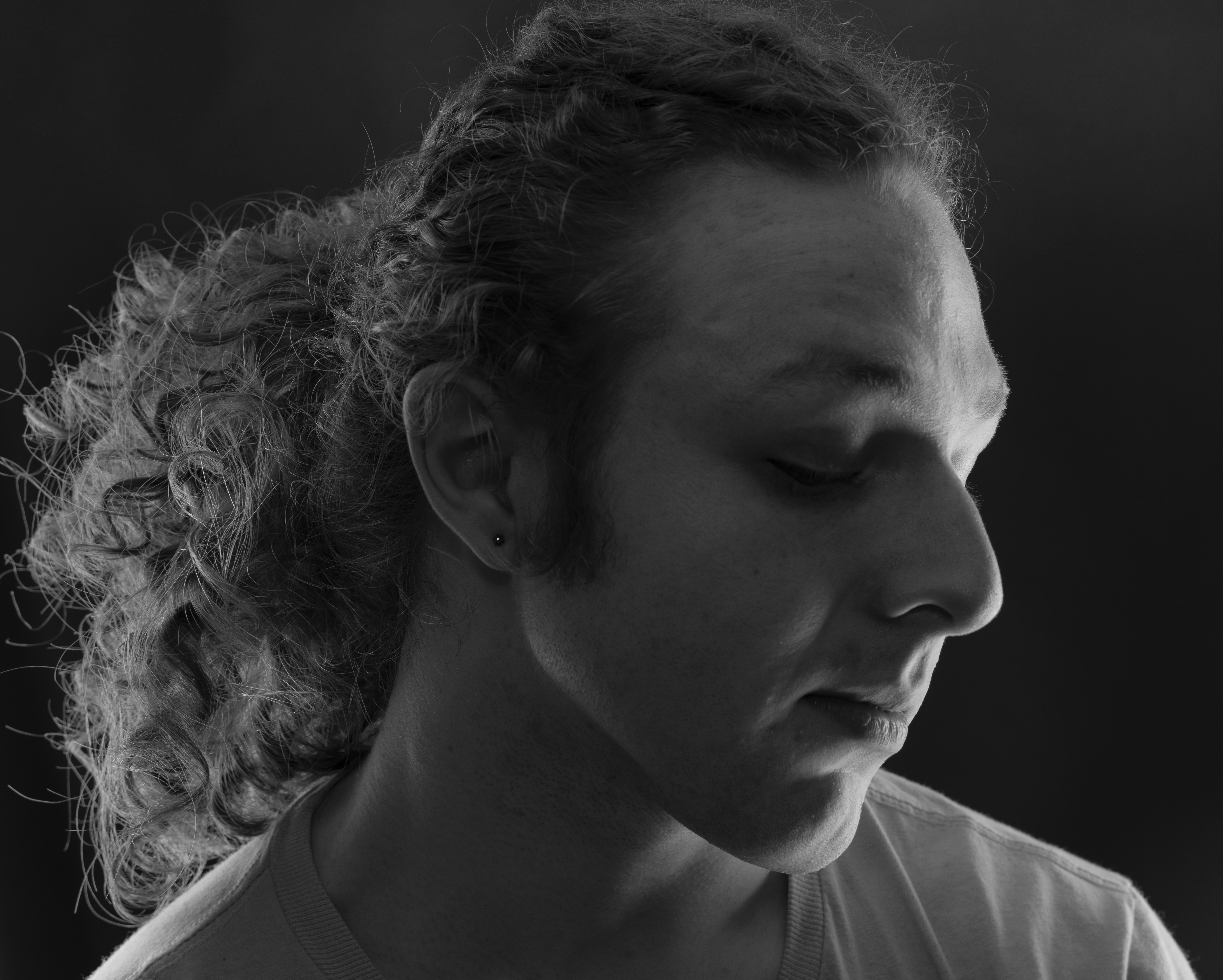 A man looks down with his eyes closed.
