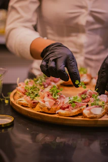 Someone is garnishing a plate of appetizers.