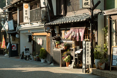 Japanese shops line a quaint, sunlit street.